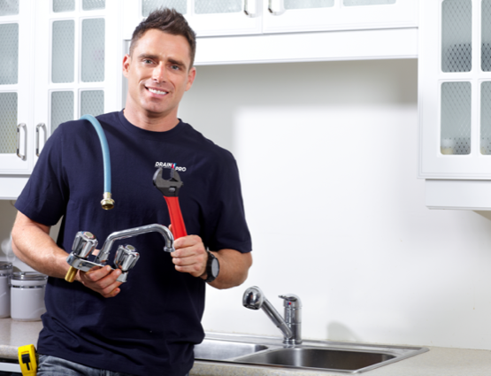 a plumber holding up the tool and equipment he'll be using to fix the kitchen plumbing in a Victoria, BC home