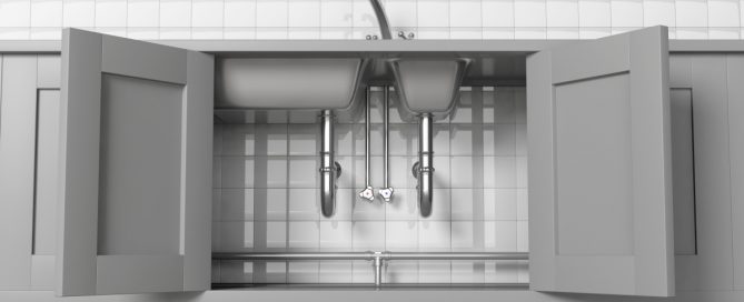 kitchen sink cabinets open with visible pipes